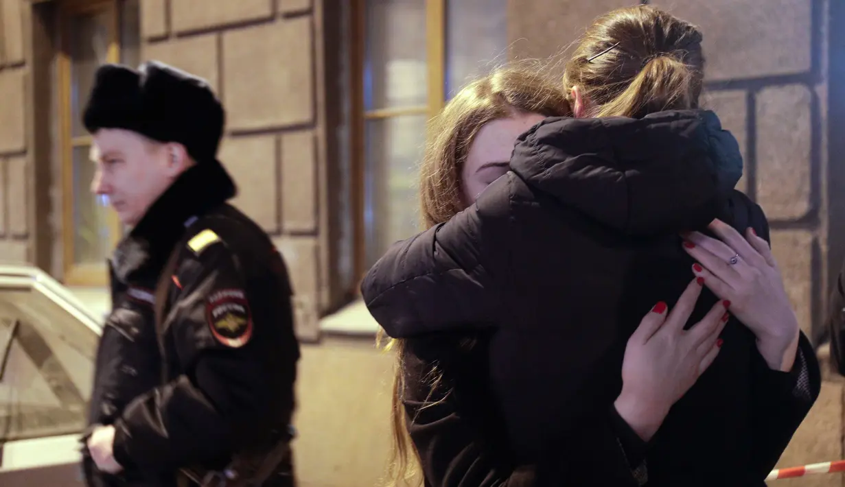 Dua warga berpelukan saat berduka di dekat lokasi ledakan bom di stasiun kereta bawah tanah St. Petersburg, Senin (3/4). Dikabarkan kejadian tersebut menewaskan 10 orang dan menghancurkan sebuah gerbong kereta. (AP Photo / Dmitri Lovetsky)
