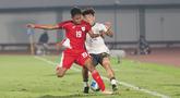 Pemain Timnas Indonesia U-17, Sean Rahman berduel dengan pemain China U-17, Kuang Zholei dalam pertandingan uji coba internasional di Indomilk Arena, Tangerang, pada Rabu (11/2/2026) malam WIB. (Bola.com/Abdul Aziz)