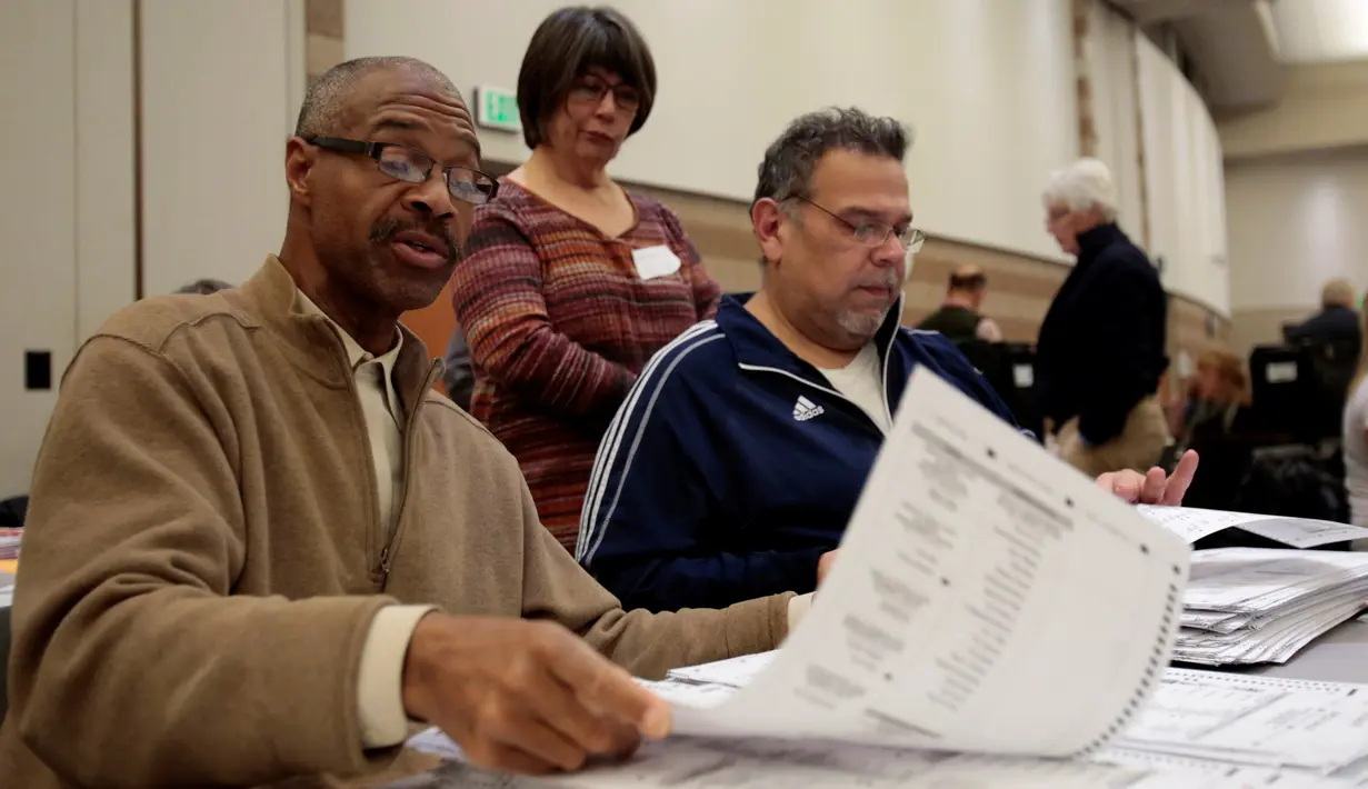 Petugas Oakland County melakukan penghitungan ulang surat suara pemilihan Presiden AS di Waterford Township, Michigan, Amerika Serikat (5/12). (Reuters/Rebecca Cook)