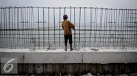 Pekerja menyelesaikan pembangunan Dam (dinding penahan ombak) di kawasan Pasar Ikan Muara Baru, Jakarta, Senin (3/10). Pemprov DKI Jakarta akan mempercepat pembangunan tanggul laut guna mencegah terjadinya kembali banjir rob. (Liputan6.com/Faizal Fanani)