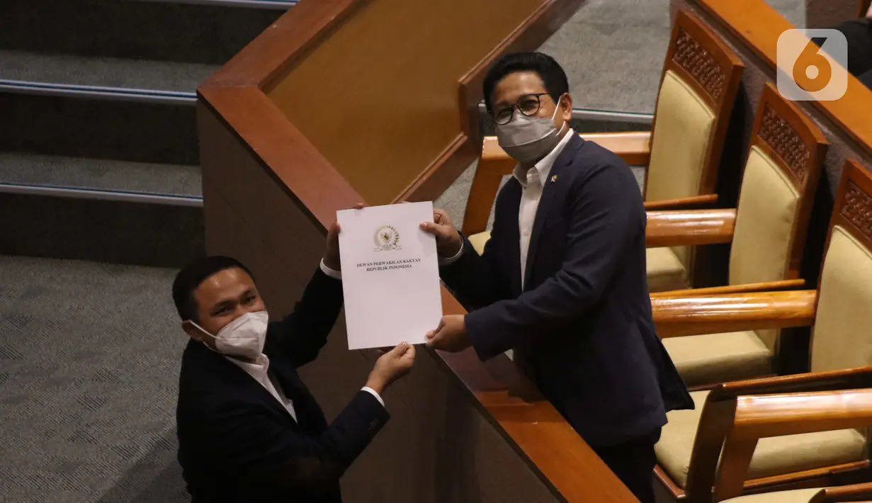 Menteri Desa, Pembangunan Daerah Tertinggal, dan Transmigrasi (Mendes PDTT) Abdul Halim Iskandar (kanan) menerima dokumen saat sidang paripurna ke-14 masa persidangan III tahun sidang 2021-2022 di Gedung Nusantara II, Kompleks Parlemen, Jakarta, Selasa (8/2/2022). (Liputan6.com/Angga Yuniar)
