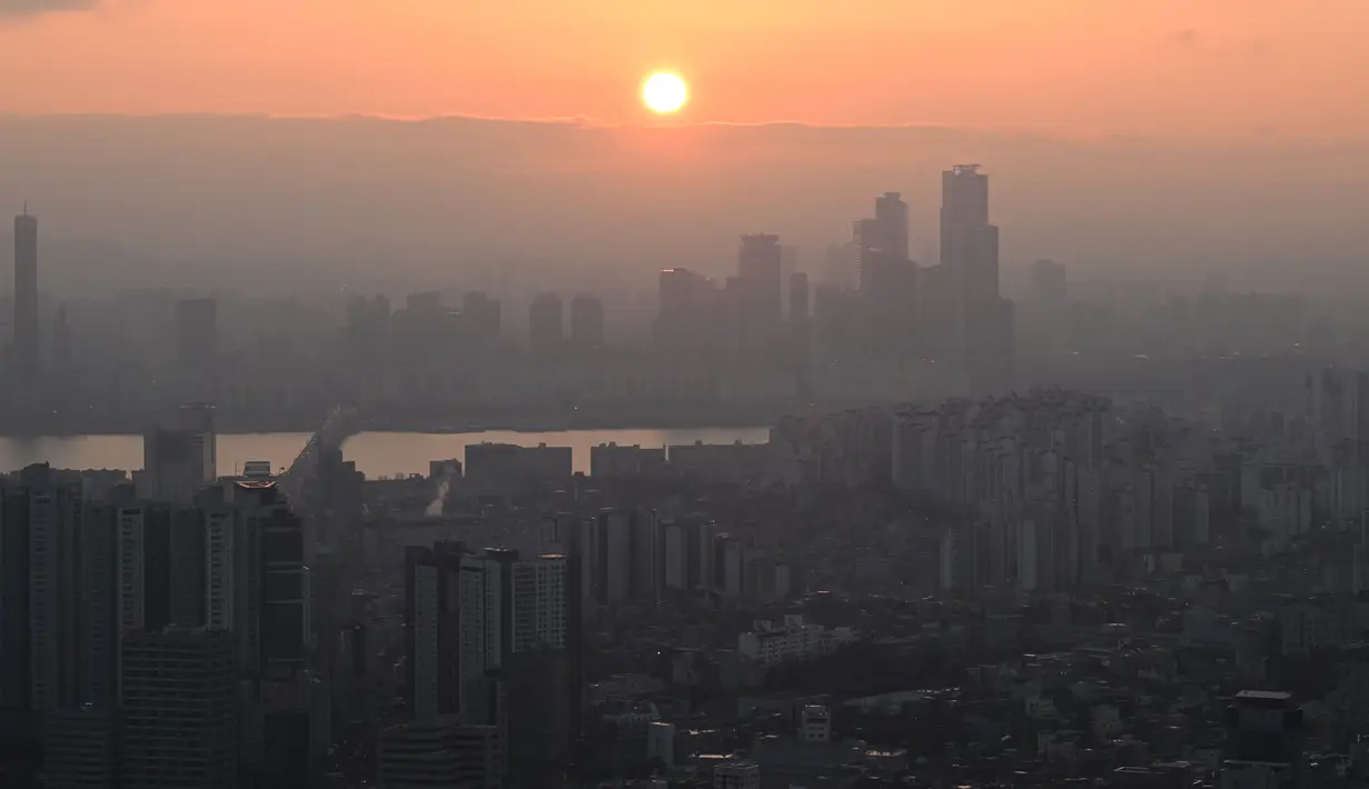 Momen matahari terbenam terakhir 2023 tidak dilewati sebagian orang, termasuk orang-orang di Korsel yang menikmati sunset itu dari menara Namsan. (Jung Yeon-je / AFP)