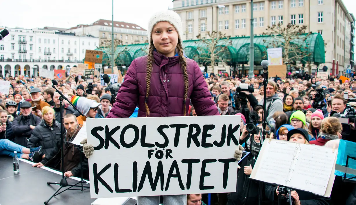 Aktivis iklim asal Swedia, Greta Thunberg memegang poster protes saat berunjuk rasa di Hamburg, Jerman, Jumat (1/3). Aksi 'Fridays for Future' ini diikuti oleh ribuan pelajar yang bolos sekolah. (Daniel Reinhardt/dpa via AP)