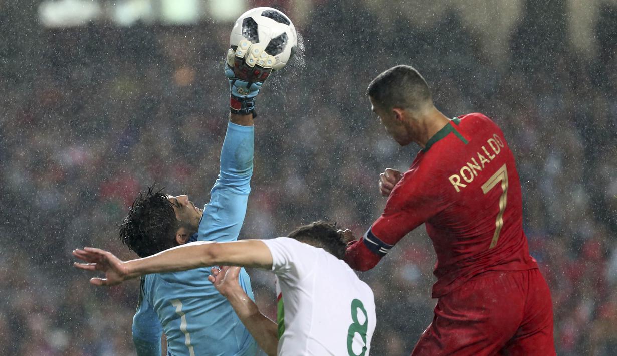 Striker Portugal, Cristiano Ronaldo, duel udara dengan kiper Aljazair, Abdelkaadir Salhi, pada laga uji coba di Estadio da Luz, Jumat (8/6/2018). Portugal menang 3-0 atas Aljazair. (AP/Armando Franca)