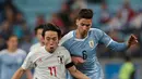 Gelandang Jepang, Koji Miyoshi menggiring bola dari kawalan gelandang Uruguay, Rodrigo Bentancur  selama pertandingan grup C Copa America 2019 di Arena Gremio di Porto Alegre, Brasil (20/6/2019). Koji Miyoshi mencetak dua gol dipertandingan ini.  (AP Photo/Silvia Izquierdo)