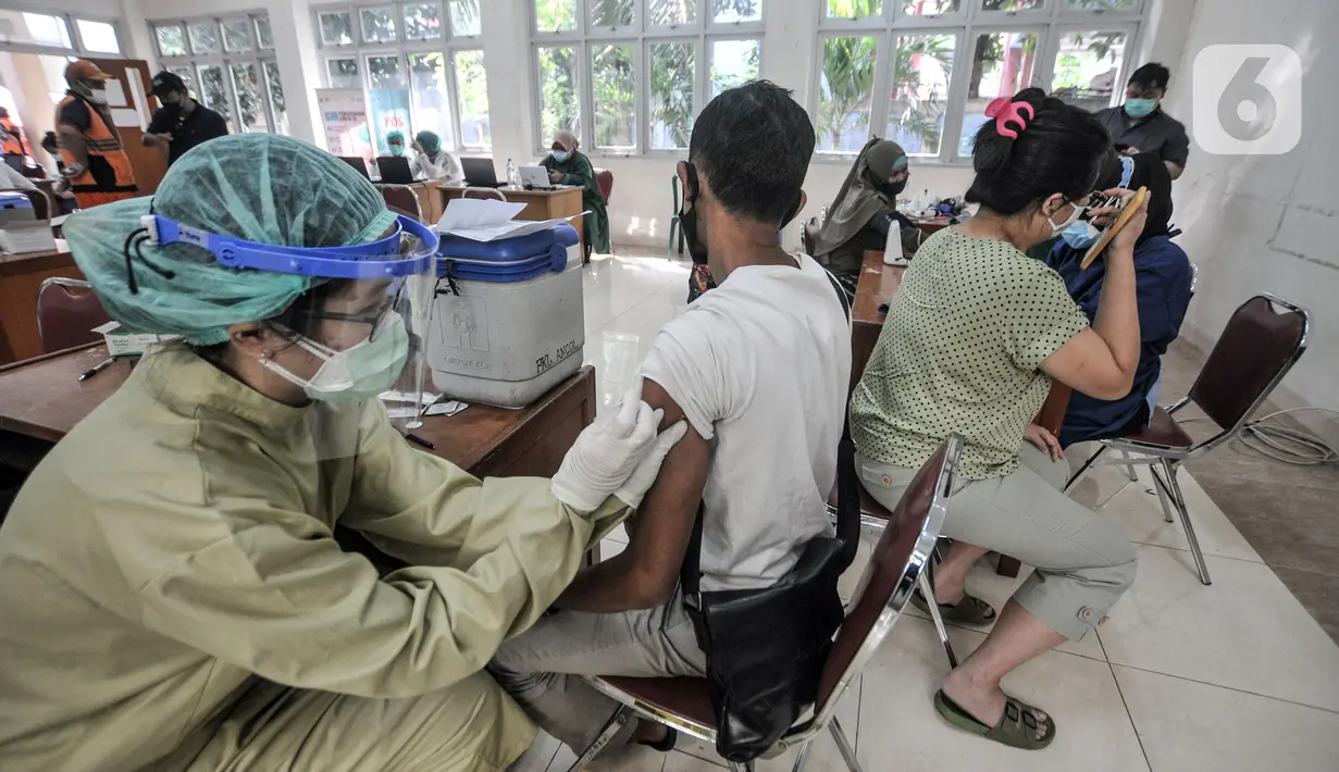 Petugas medis menyuntikkan vaksin COVID-19 kepada warga saat vaksinasi di Kantor Kelurahan Ancol, Jakarta, Kamis (17/6/2021). LMK Kelurahan Ancol menargetkan vaksinasi COVID-19 dapat diterima oleh 400 orang per hari. (merdeka.com/Iqbal S. Nugroho)