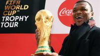 Mantan bek Prancis, Marcel Desailly berpose dengan trofi Piala Dunia dengan latar menara Eiffel selama FIFA World Cup Trophy Tour di Paris (20/3). Piala Dunia 2018 diselenggarakan 14 Juni dan 15 Juli 2018 di Rusia. (AFP Photo/Franck Fife)