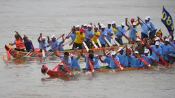 Peserta mendayung perahu naga menuju garis finish selama Festival Air di sungai Tonle Sap, Phnom Penh, Senin (11/11/2019). Cambodian Water Festival atau Bon Om Touk yang digelar pada 10-12 November ini merupakan salah satu festival terbesar dan paling populer di Kamboja. (TANG CHHIN Sothy/AFP)