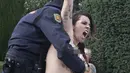 Aktivis Femen ditangkap polisi saat melakukan aksi telanjang dada memprotes penggalian makam diktator Spanyol Francisco Franco selama pertemuan tahunan di Madrid, Spanyol (24/11/2019). Aksi ini sekaligus memperingati kematian ke-44 Francisco Franco. (AP Photo/Paul White)