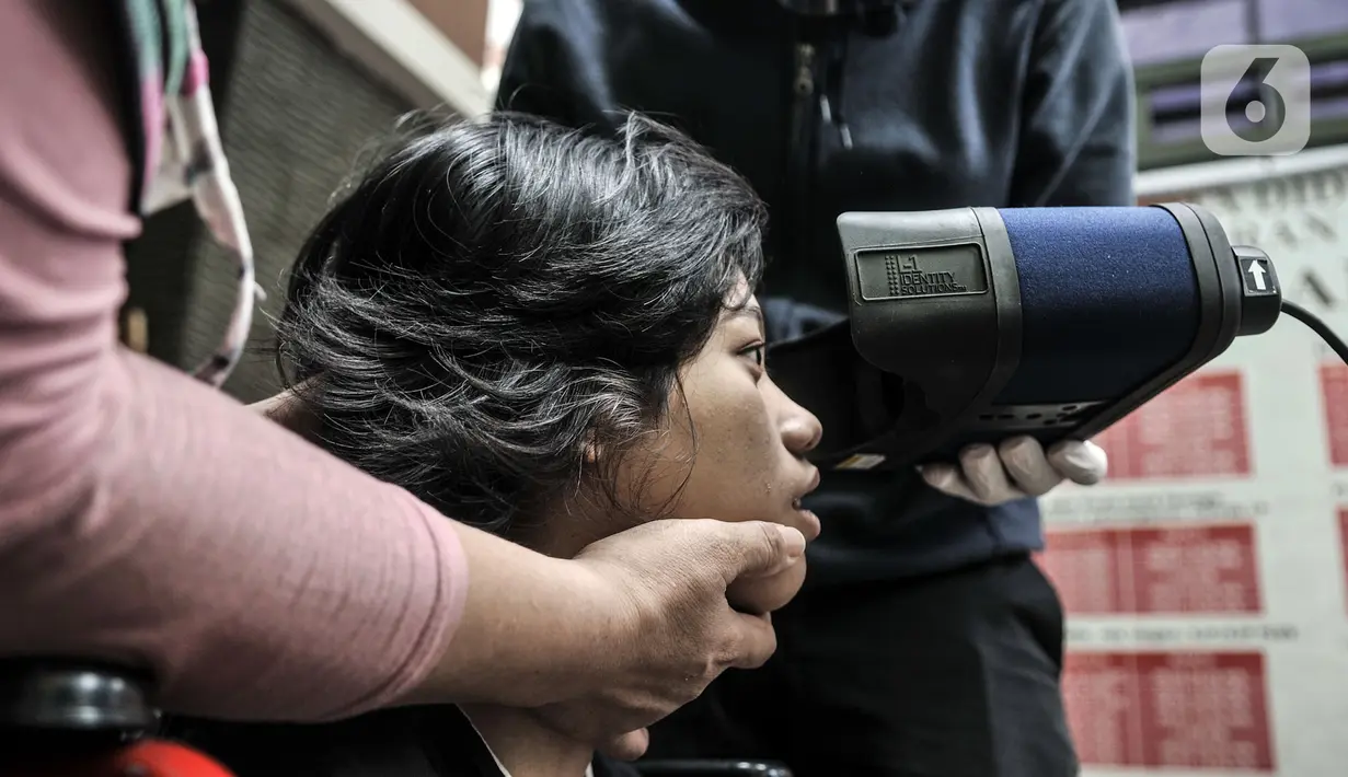 Petugas Disdukcapil Kota Jakarta Utara merekam E-KTP penyandang disabilitas di Pademangan Barat, Jakarta, Kamis (16/7/2020). Program jemput bola ini untuk memudahkan pelayanan administrasi kependudukan bagi penyandang disabilitas, jompo dan orang sakit di masa pandemi. (merdeka.com/Iqbal S. Nugroho)