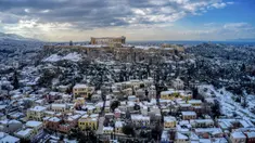 Bukit Acropolis kuno dan distrik tradisional Plaka, kawasan wisata populer di Athena, tertutup salju setelah hujan salju lebat di Athena, Yunani, Rabu (17/2/2021). Hujan salju membuat sebagian besar Athena tanpa listrik dan air selama tiga hari. (Antonis Nikolopoulos/Eurokinissi via AP)