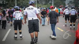 Polisi berkeliling menggunakan sepatu roda saat berpatroli di area Car Free Day, di Bundaran HI, Jakarta, Minggu (3/5/2015). Patroli polisi ini dilakukan untuk menjaga ketertiban serta keamanan bagi warga yang berolahraga. (Liputan6.com/Faizal Fanani)