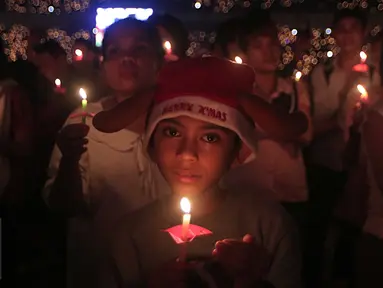 Seorang bocah laki -laki membawa lilin saat mengikuti perayaan Natal Gereja Tiberias di GBK, Jakarat, (5/12). Perayaan tema"Semua yang menerimanya, Diberinya kuasa untuk menjadi anak-anak Allah (Yohanes 1:12)".(Liputan6.com/Angga Yuniar)