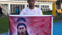 Kapten Persis Solo, Tegar Hening Pangestu membentangkan spanduk bergambar Ferry Anto di Stadion Aji Imbut, Tenggarong, Sabtu (22/6/2019). (Bola.com/Vincentius Atmaja)