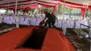 Pekerja menyiapkan karpet merah di makam Presiden ke-3 RI BJ Habibie di TMP Kalibata, Jakarta, Kamis (12/9/2019). Sejumlah petinggi dilaporkan bakal hadir menghadiri pemakaman Habibie. (Liputan6.com/Herman Zakharia)