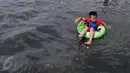 Seorang anak menggunakan pelampung saat berenang di pantai Ancol,  Jakarta, Kamis (7/7). Ancol tetap menjadi primadona tempat wisata bagi warga Jakarta dan sekitar untuk mengisi libur Lebaran. (Liputan6.com/Johan Tallo)
