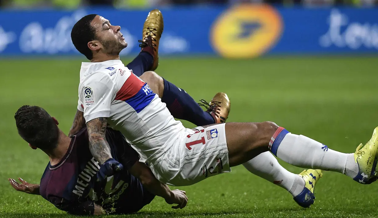 Penyerang Lyon, Memphis Depay (kanan) saat dilanggar bek PSG, Thomas Meunier saat bertanding pada lanjutan Liga Prancis di stadion Grupama, Decines-Charpieu (21/1). Lyon menang 2-1 atas PSG. (AFP Photo/Jeff Pachoud)