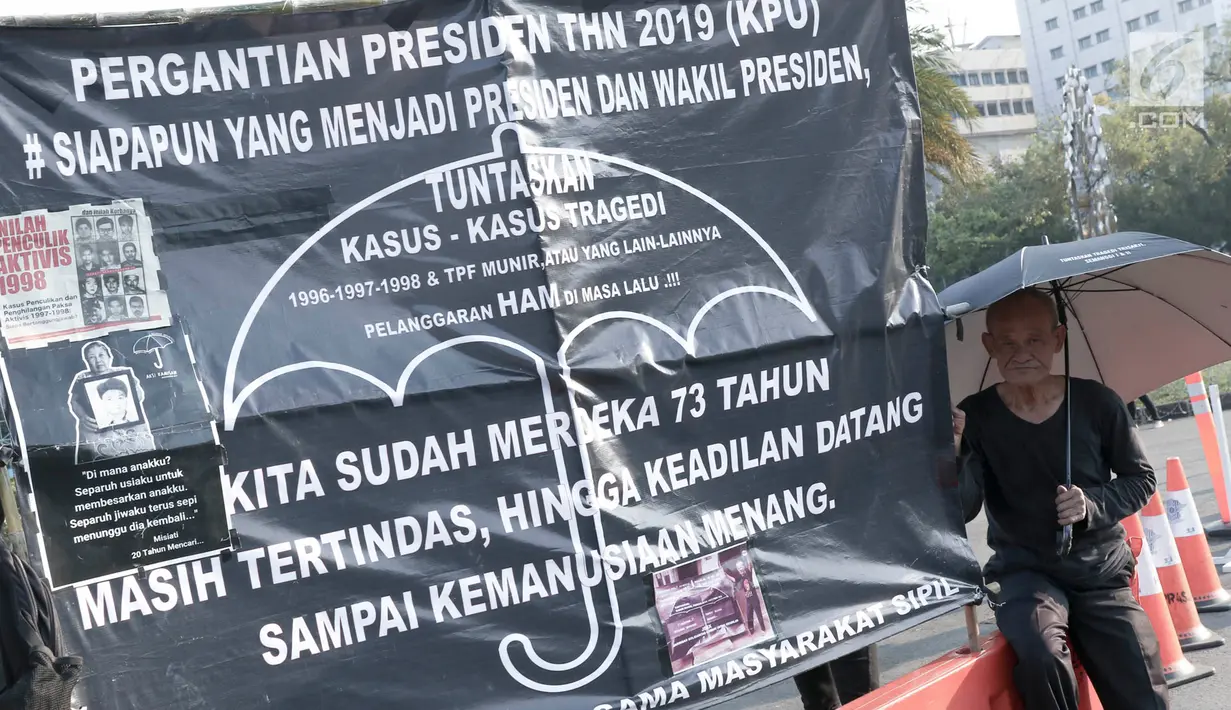 Massa Jaringan Solidaritas Korban untuk Keadilan (JSKK) duduk di samping spanduk saat menggelar aksi Kamisan di depan Istana Negara, Jakarta, Kamis (30/8). Aksi ini memasuki yang ke-551. (Liputan6.com/Immanuel Antonius)