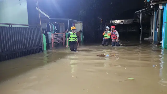 Banjir di Perumahan Sawangan Asri akibat luapan air Kali Pesanggrahan, Sawangan, Depok, Minggu malam (9/3/2025). (Liputan6.com/Dicky Agung Prihanto)