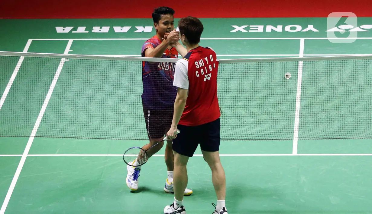 Pebulu tangkis tunggal putra Indonesia Anthony Sinisuka Ginting (kiri) bersalaman dengan tunggal putra China Shi Yu Qi saat bertanding pada babak 16 besar Indonesia Masters 2023 di Istora Senayan, Jakarta, Kamis (26/1/2023). Anthony Sinisuka Ginting terhenti di babak 16 besar Indonesia Masters 2023 setelah kalah dari Shi Yu Qi dengan skor 19-21 dan 16-21. (Liputan6.com/Herman Zakharia)