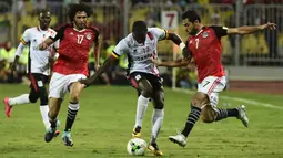 Pemain Mesir, Ahmed Fathy (kanan) dan Mohamed el-Nenny (kiri) mengadang laju pemain Uganda, Farouk Miya (tengah) pada laga kualifikasi Piala Dunia 2018 di Borg El Arab Stadium, Alexandria, Mesir (5/9/2017). Mesir menang 1-0. (AFP/Khaled Desouki)