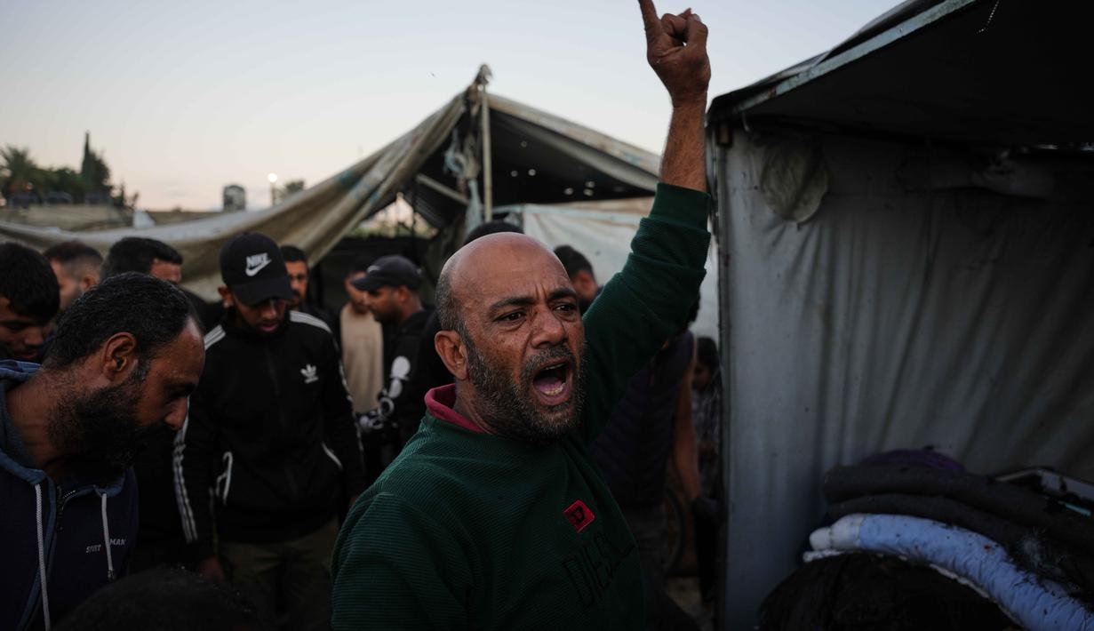 Warga Palestina yang mengungsi berkumpul di samping tenda-tenda mereka yang hancur akibat pemboman Israel di Deir al-Balah, Jalur Gaza, Rabu 29 Oktober 2025. Berdasarkan ketentuan gencatan senjata, Israel menarik kembali pasukannya dan menghentikan serangannya. (AP Photo/Abdel Kareem Hana)