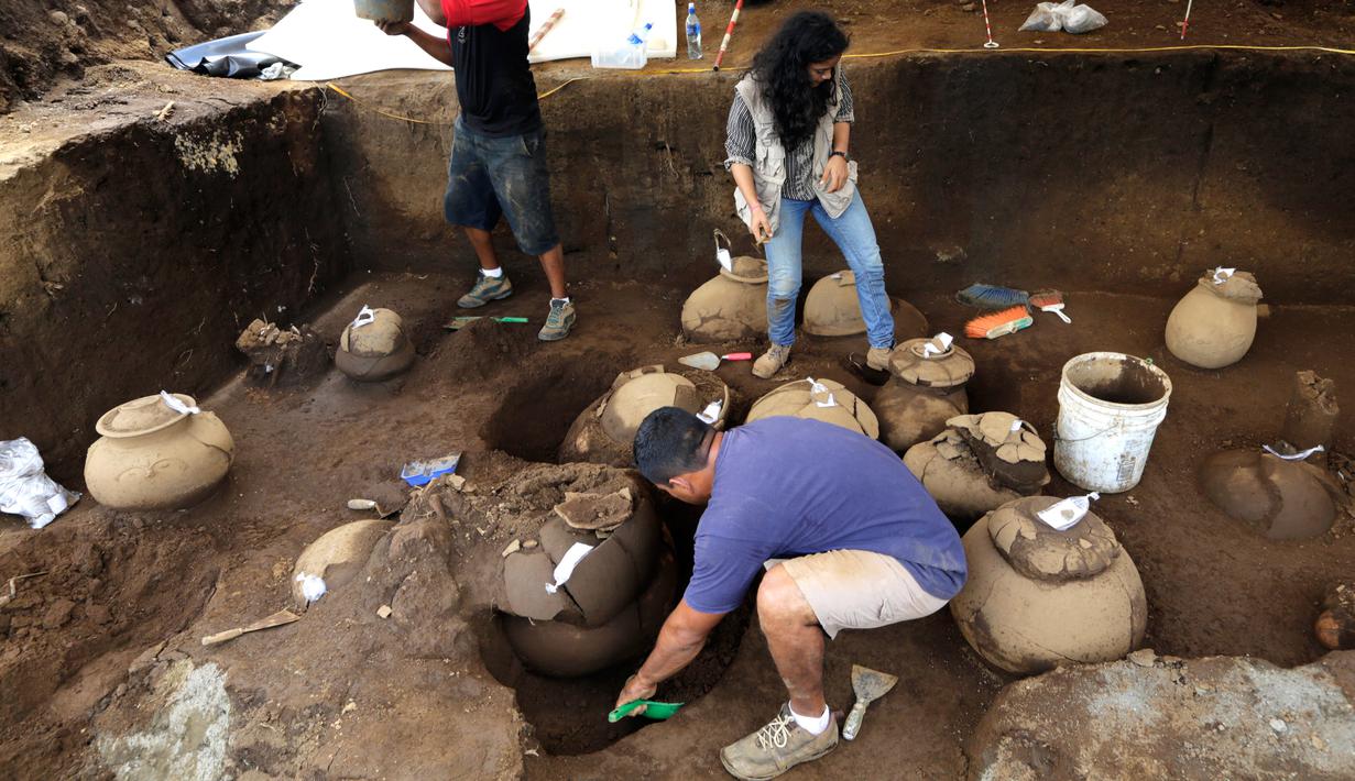 Pekerja Nicaraguan Institute of Culture (INC) menggali puluhan tembikar yang ditemukan di situs pemakaman zaman pra-Kolombia berusia lebih dari 1.200 tahun di lokasi pembangunan Stadion Bisbol Nasional yang baru di Managua, Selasa (20/6). (INTI OCON/AFP)