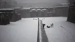 Orang-orang berjalan di sepanjang taman Vuelta del Castillo saat salju menutupi kota pada hari musim semi, di Pamplona, Spanyol utara (2/4/2022). Pihak berwenang mengumumkan suhu rendah untuk hari-hari berikutnya. (AP Photo/Alvaro Barrientos)
