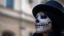 Peserta mengenakan kostum dan dandanan menyerupai zombie selama acara Zombie Walk di Sao Paulo, Brasil, Sabtu (2/11/2019). Ratusan orang turun ke jalan memakai kostum karakter horor pada acara tahunan yang digelar sejak 2006 pada Hari Para Arwah. (Miguel SCHINCARIOL / AFP)