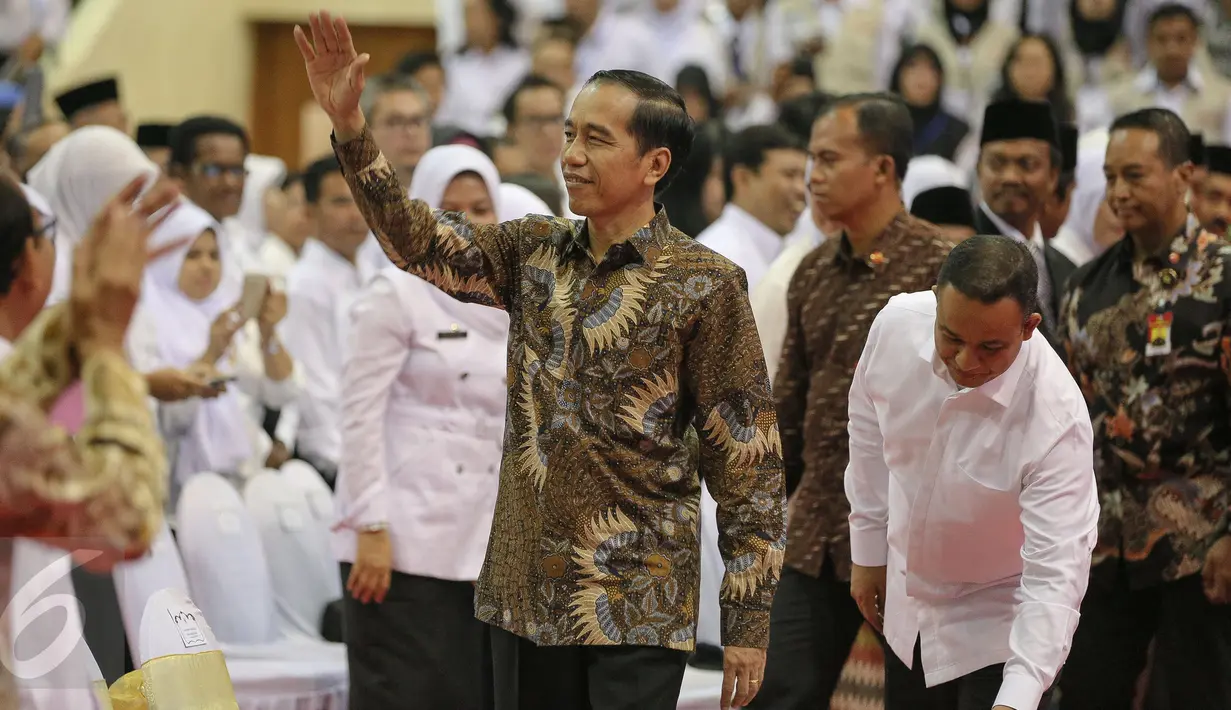 Presiden Joko Widodo (Jokowi) melambaikan tangan saat hadir dalam Peringatan Hari Guru Nasional 2015, Istora Senayan, Jakarta, Selasa (24/11). Peringatan hari guru tahun ini mengangkat tema 'Guru Mulia Karena Karya'. (Liputan6.com/Faizal Fanani)