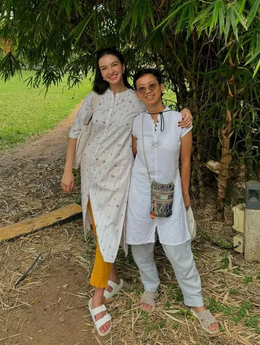 Raline juga tampak mengenakan tunik putih yang memiliki motif dipadukan celana panjang kuning. Serta sandal dan tote bag putihnya. [@ralineshah]