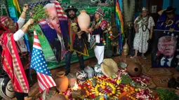 Dukun melakukan ritual mistik dengan memegang gambar calon presiden dari Partai Demokrat Joe Biden dan pesaingnya Donald Trump, di Lima, Peru, Rabu (16/9/2020). Mereka mencoba memprediksi siapa pemenang dari pemilihan presiden AS yang akan dihelat pada 3 November mendatang. (AP Photo/Rodrigo Abd)