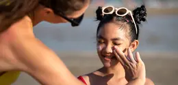 Seorang Ibu Sedang Mengoleskan Sunscreen Pada Anak (freepik)