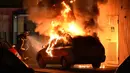 Seorang petugas pemadam kebakaran menyemprotkan air untuk memadamkan mobil yang terbakar di wilayah Mirail, Toulouse, Prancis (17/4). Sejumlah pemuda di kawasan Mirail mengamuk, mereka membakar mobil dan menyerang polisi. (AFP/Remy Gabalda)