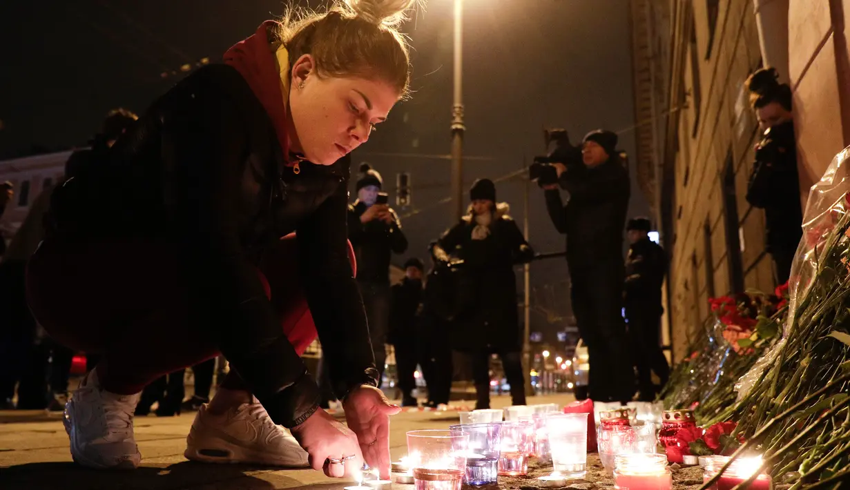 Warga meletakan meletekan lilin di dekat lokasi ledakan bom di stasiun kereta bawah tanah St. Petersburg, Senin (3/4). Dikabarkan kejadian tersebut menewaskan 10 orang dan menghancurkan sebuah gerbong kereta. (AP Photo / Dmitri Lovetsky)