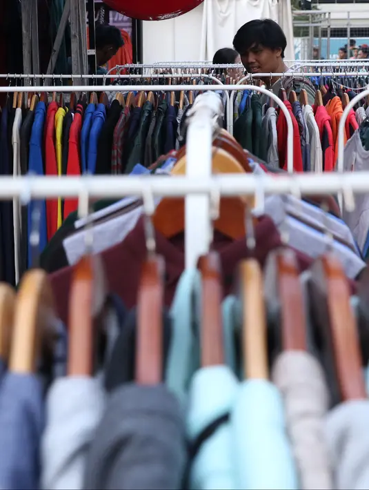 Pengunjung memilih koleksi pakaian di salah satu stand pada gelaran JakCloth di halaman Istora Senayan, Jakarta, Senin (4/6). Beragam merek pakaian anak muda dihadirkan pada gelaran yang berlangsung hingga 10 Juni 2018. (Liputan6.com/Helmi Fithriansyah)