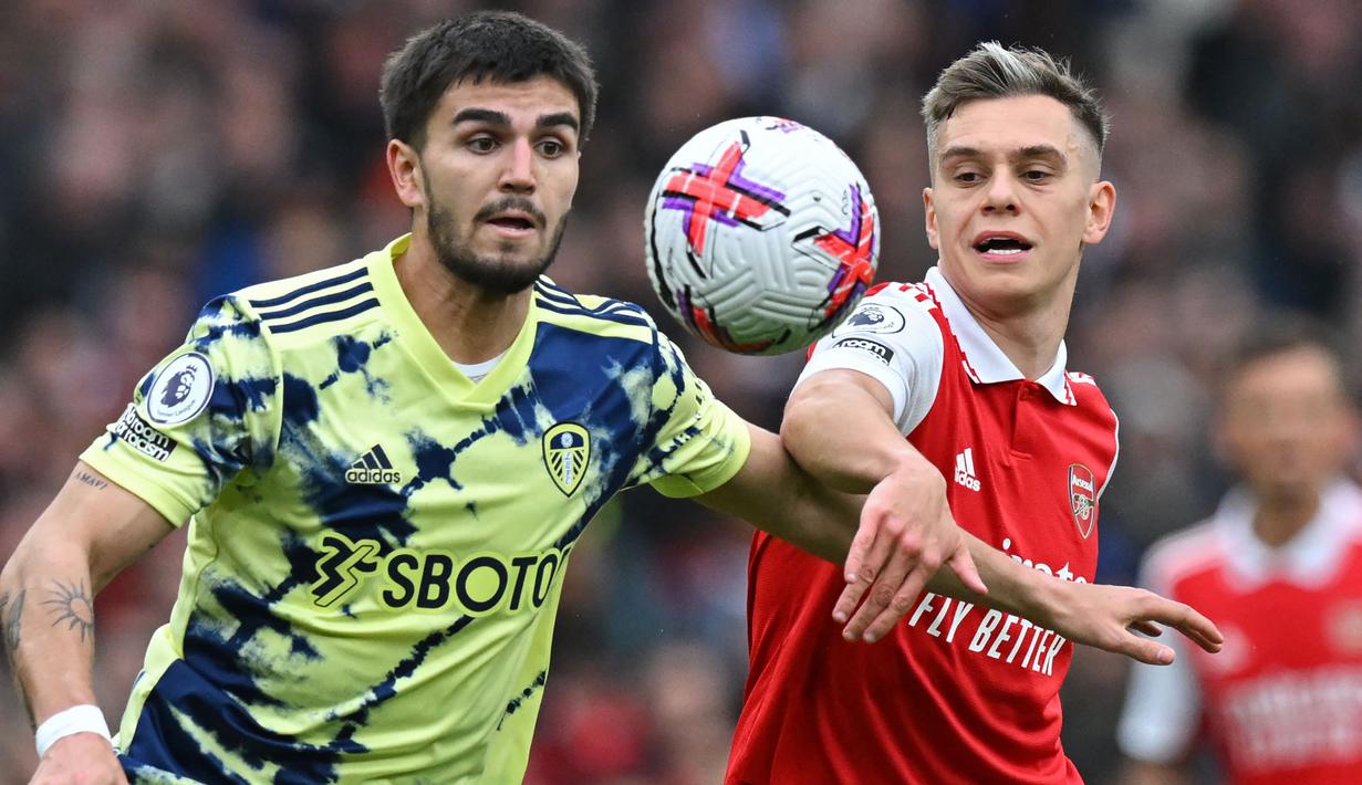 Pemain Arsenal, Leandro Trossard (kanan) berebut bola dengan pemain Leeds United, Pascal Struijk pada laga pekan ke-29 Liga Inggris 2022/2023 di Emirates Stadium, London, Minggu (02/04/2023) dini hari WIB. The Gunners menang dengan skor 4-1. (AFP/Glyn Kirk)