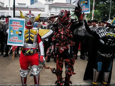 Sejumlah buruh mengenakan kostum cosplay super hero ketika berunjuk rasa di depan Balai Kota, Jakarta, Kamis (29/9). Dalam aksinya, buruh menuntut kenaikan upah mininum Rp 650ribu dan penghapusan Tax Amnesty. (Liputan6.com/Faizal Fanani)