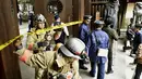 Petugas Polisi dan pemadam kebakaran saat melakukan investigasi di gerbang selatan Yasukuni Shrine dimana ledakan terjadi, Tokyo, Jepang, (23/11). Kuil ini merupakan simbol militerisme Jepang di masa lalu (REUTERS/Kyodo)
