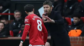 Pelatih sementara Manchester United asal Inggris, Michael Carrick, berbicara dengan gelandang Manchester United asal Portugal bernomor punggung 08, Bruno Fernandes, selama pertandingan Liga Inggris antara Manchester United dan Manchester City di Old Trafford, Manchester, barat laut Inggris, pada 17 Januari 2026. (Darren Staples/AFP)