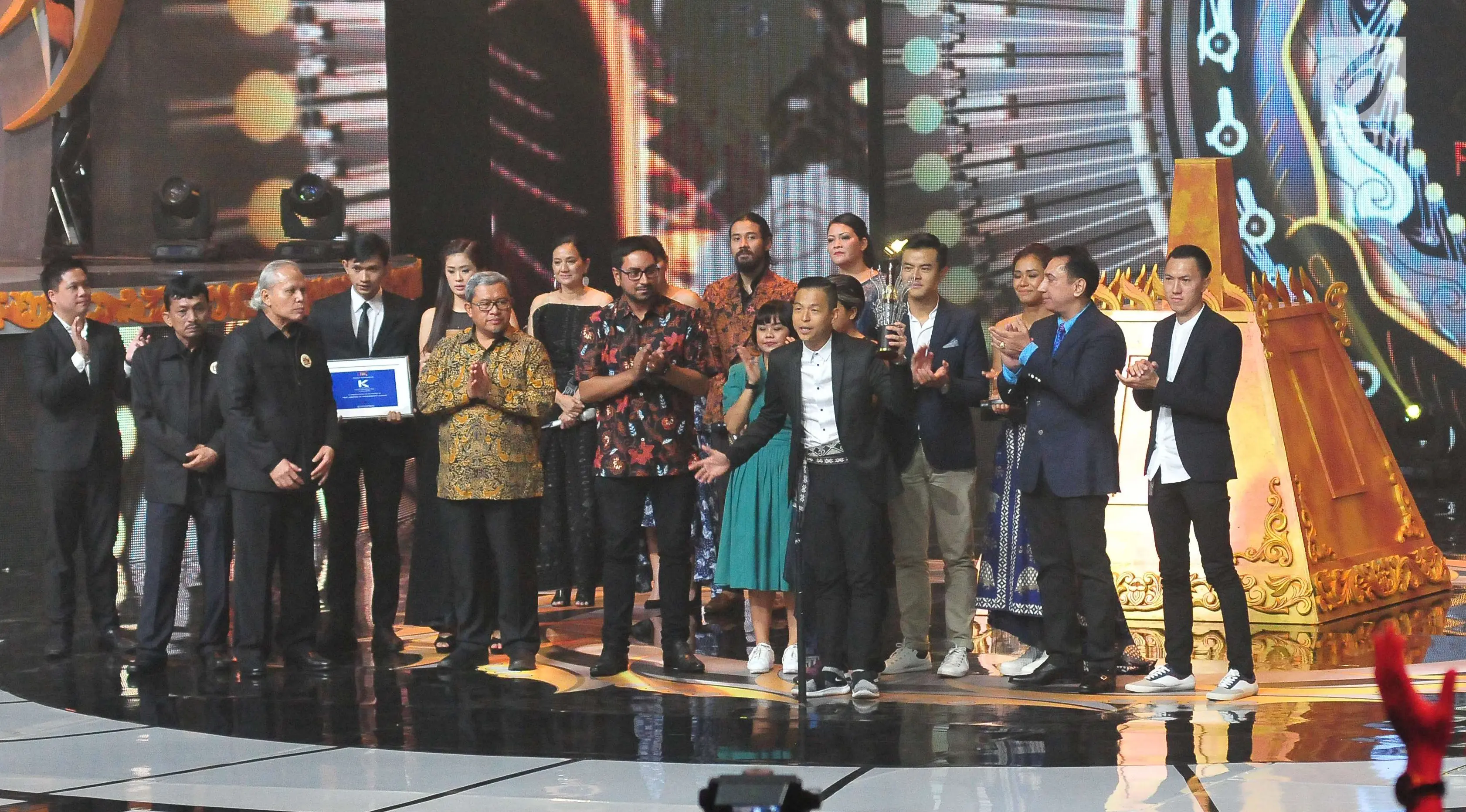 	Ernest Prakasa mengangkat piala usai film Bioskop Cek Toko Sebelah dinobatkan menjadi Film Terpuji dalam ajang Festival Film Bandung 2017 di studio 6 Emtek, Jakarta (22/10). (Liputan6.com/Helmi Afandi)