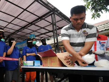 Petugas BNN membongkar kardus berisi narkotika jenis sabu yang disita dari dua kelompok pengedar di Gedung BNN Jakarta, Kamis (29/10/2015). Sabu seberat 22,4 kg dimusnahkan BNN dihadapan sejumlah saksi dan tersangka. (Liputan6.com/Helmi Fithriansyah)