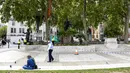 Polisi berpatroli saat aktivis Extinction Rebellion menaiki dua pohon di Parliament Square sebagai bagian dari protes perubahan iklim di London, Inggris, Selasa (8/9/2020). Menggelar aksi di tengah pandemi COVID-19, para aktivis mengenakan masker selama protes berlangsung. (AP Photo/Alberto Pezzali)