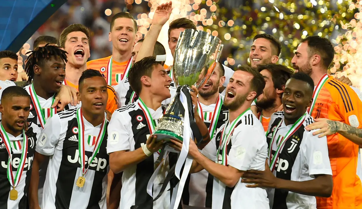 Pemain Juventus, Paulo Dybala dan Miralem Pjanic mengangkat trofi Piala Super Italia 2018 seusai mengalahkan AC Milan pada laga final di King Abdullah Sports City, Kamis (17/1). Juventus keluar sebagai kampiun dengan meraih kemenangan tipis 1-0 (AP Photo)