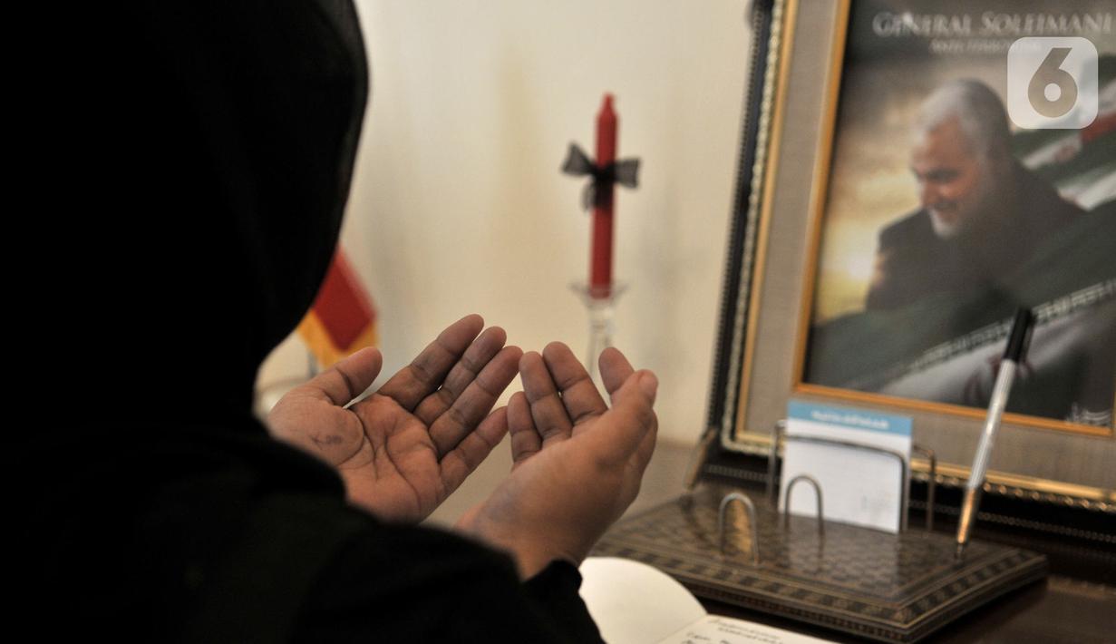 Warga berdoa usai menuliskan memo belasungkawa atas wafatnya Panglima Garda Revolusi Iran Jenderal Qasem Soleimanidi Kedutaan Besar Iran, Jakarta, Selasa (7/1/2020). (merdeka.com/Iqbal S. Nugroho)