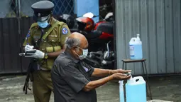 Seorang pemilih membersihkan tangan sebelum memasuki tempat pemungutan suara di Kolombo, Sri Lanka, Rabu (5/8/2020). Sri Lanka menggelar pemilihan parlemen di tengah pandemi COVID-19. (Ishara S. KODIKARA/AFP)