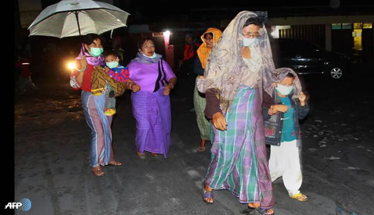 Wanita dan anak-anak berjalan menuju tempat pengungsian. Tinggi abu vulkanik letusan 3.000 meter dari kawah dan terbawa angin ke barat daya. (AFP/Karishma Tarigan/wwn)