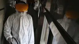 Petugas melakukan penyemprotan disinfektan pada gerbong kereta api di Stasiun Pasar Senen, Jakarta, Minggu (15/3/2020). PT KAI Daop I Jakarta melakukan penyemprotan disinfektan dan pembersihan KA jarak jauh untuk antisipasi dan pencegahan penyebaran COVID-19. (Liputan6.com/Herman Zakharia)
