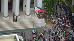 Pegawai pengadilan berkumpul di depan gedung setelah gempa melanda Manila, Filipina (11/8). Gempa bertenaga 6,2 skala Richter mengguncang wilayah selatan ibukota Filipina yang menyebabkan bangunan di Manila rusak. (AFP Photo/Ted Aljibe)