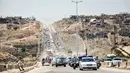 Mobil-mobil pemerintah dan kendaraan militer melintasi jalan raya utama antara Homs dan Hama di Suriah tengah, Rabu (6/6). Pemerintah Suriah membuka kembali jalan raya Homs-Hama setelah ditutup selama hampir tujuh tahun. (AFP/STRINGER)